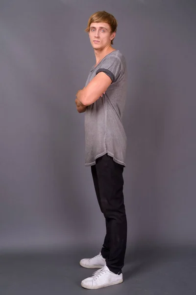 Joven hombre guapo con el pelo rubio sobre fondo gris —  Fotos de Stock