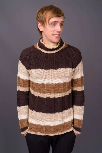 스튜디오에서 잘생긴 남자가 배경에 터틀넥 스웨터를 — 스톡 사진