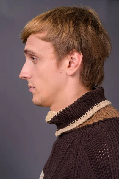 Joven hombre guapo con el pelo rubio sobre fondo gris —  Fotos de Stock