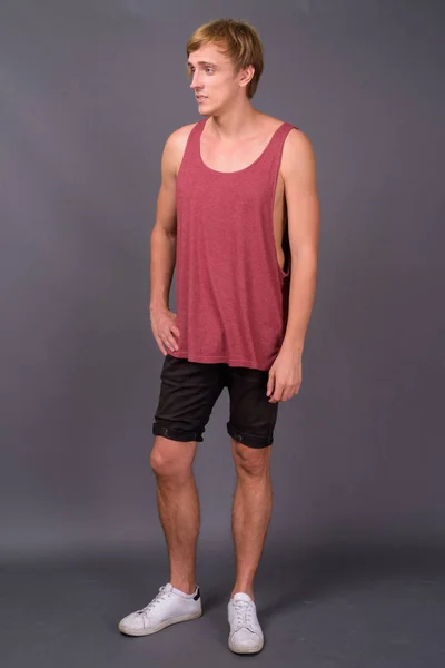 Young handsome man ready for gym against gray background — Stock Photo, Image