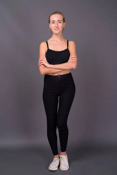 Ung vacker kvinna redo för gym mot grå bakgrund — Stockfoto