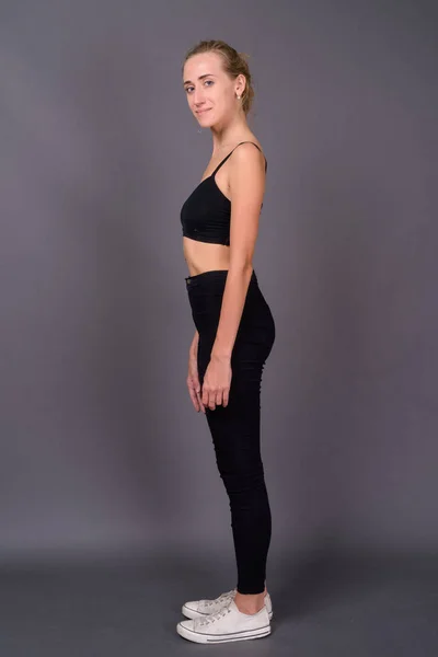 Junge schöne Frau bereit für Fitnessstudio vor grauem Hintergrund — Stockfoto