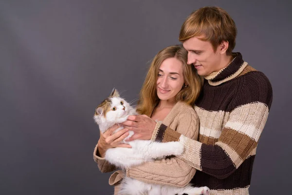Портрет молодої пари разом, тримаючи персидський кіт — стокове фото