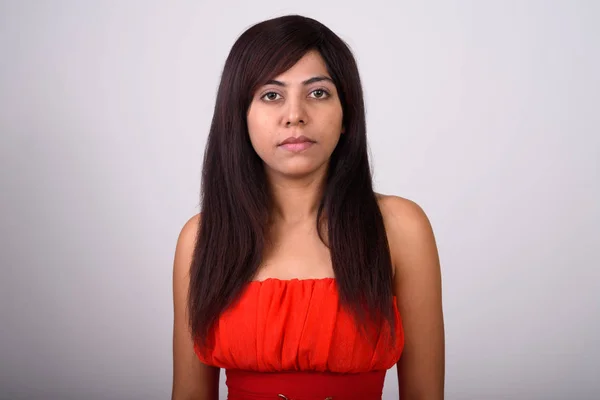 Close up de jovem mulher persa vestindo vestido vermelho contra cinza b — Fotografia de Stock