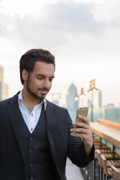 Jeune homme d'affaires indien beau en utilisant le téléphone mobile sur le toit — Photo