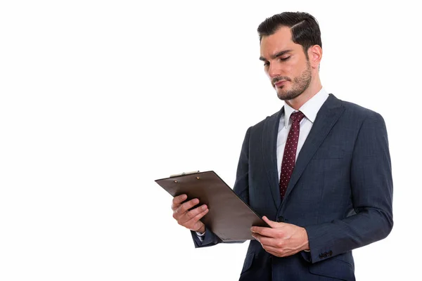 Estudio de toma de joven hombre de negocios guapo mirando portapapeles — Foto de Stock