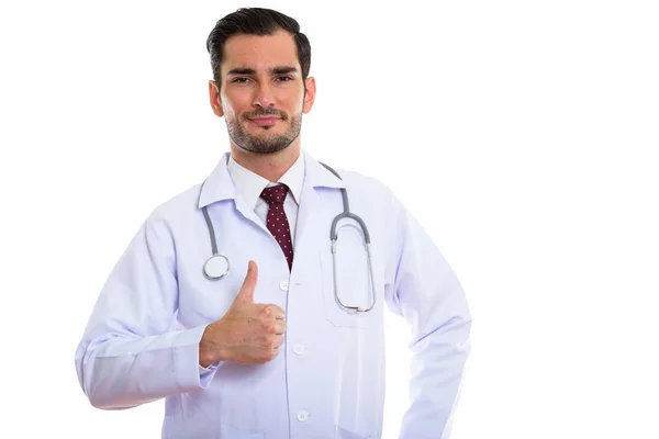 Studio shot of young handsome man doctor giving thumb up — Stock Photo, Image