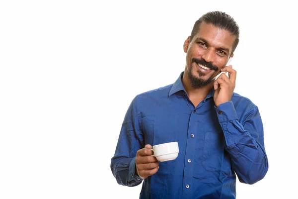 Młody szczęśliwy indyjski biznesmen rozmowy na telefon komórkowy, podczas gdy hol — Zdjęcie stockowe