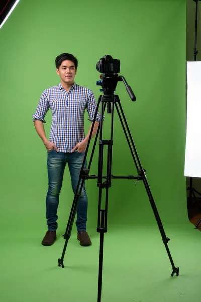 Jovem filipino bonito contra fundo verde — Fotografia de Stock