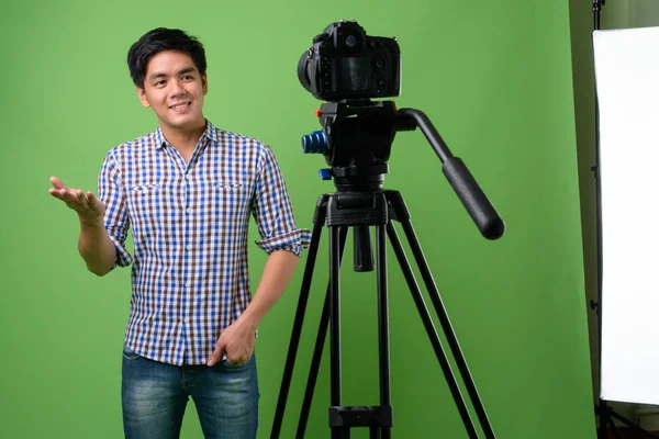 Junger hübscher philippinischer Mann vor grünem Hintergrund — Stockfoto