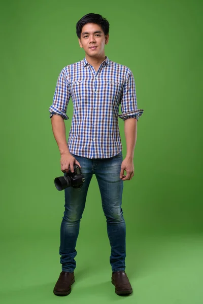 Jovem filipino bonito contra fundo verde — Fotografia de Stock