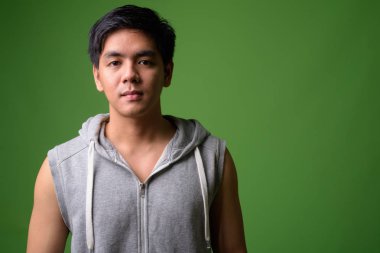 Genç yakışıklı Filipinli adam yeşil arka plana karşı