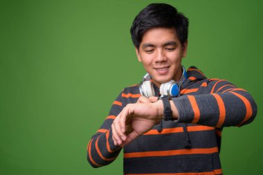 Genç yakışıklı Filipinli adam yeşil arka plana karşı