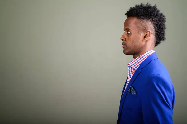 Jonge knappe Afrikaanse zakenman dragen pak tegen gekleurde — Stockfoto