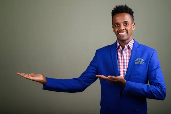 Junge gut aussehende afrikanische Geschäftsmann trägt Anzug gegen farbige — Stockfoto