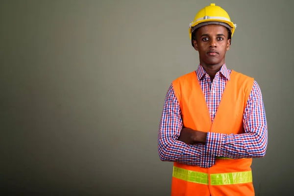 Jovem bonito homem africano trabalhador de construção contra colorido b — Fotografia de Stock