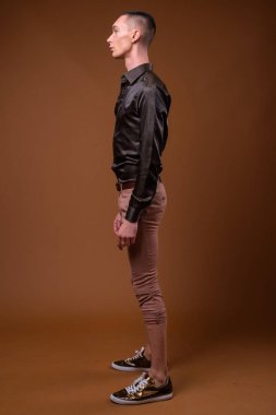 Genç yakışıklı çift cinsiyetli işadamı kahverengi zemin karşı