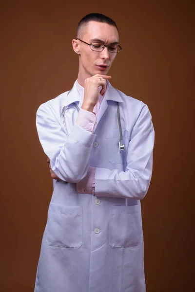 Jeune beau androgyne homme médecin sur fond brun — Photo