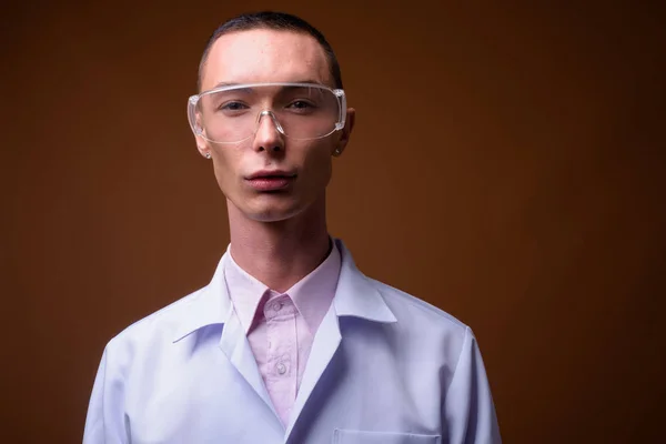 Giovane bello androgino uomo medico indossa occhiali protettivi — Foto Stock