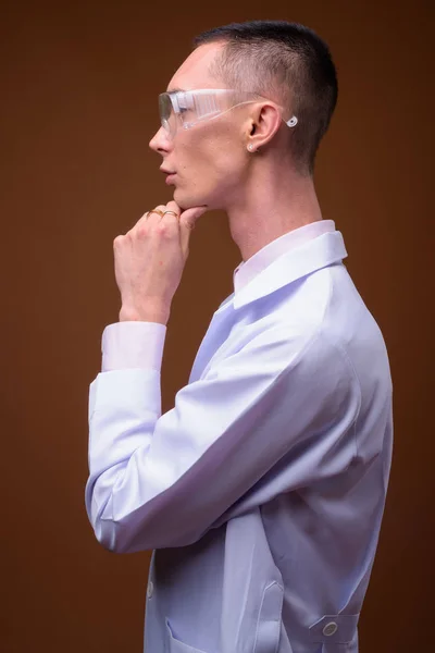 Giovane bello androgino uomo medico indossa occhiali protettivi — Foto Stock