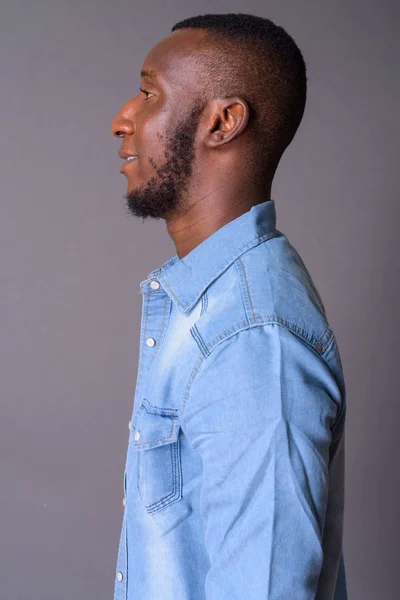 Studio Záběr Mladého Pohledného Afrického Muže Krátkými Vlasy Proti Šedému — Stock fotografie