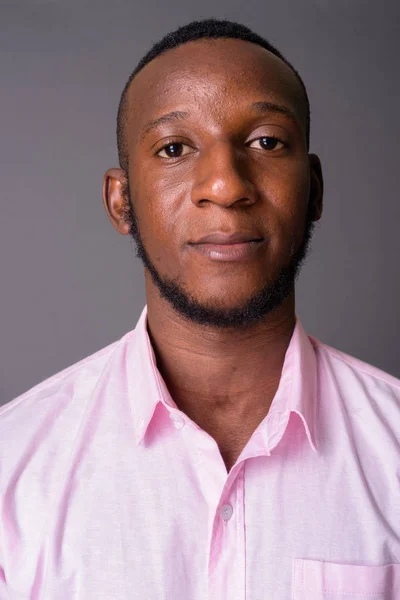 Joven hombre africano guapo con el pelo corto contra el fondo gris —  Fotos de Stock