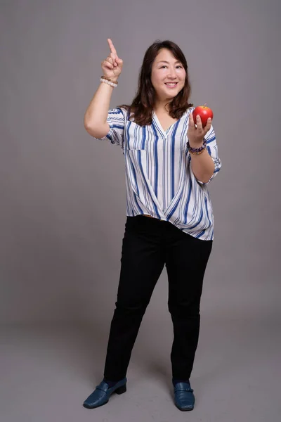 Retrato de comprimento total de empresária japonesa segurando maçã — Fotografia de Stock