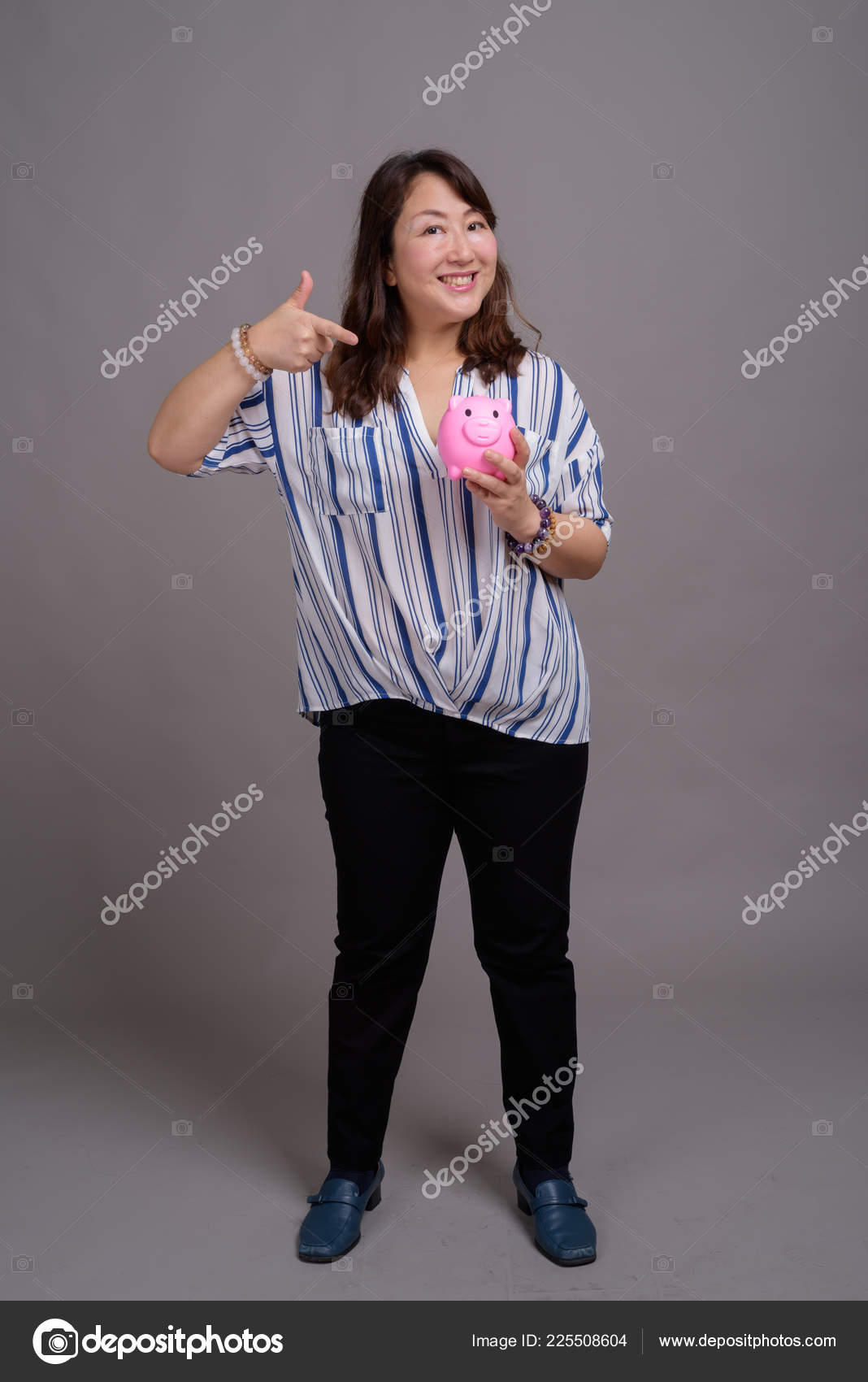 Portrait Of Japanese Mature Businesswoman Holding Piggy Bank Stock Photo Image By C Amazingmikael