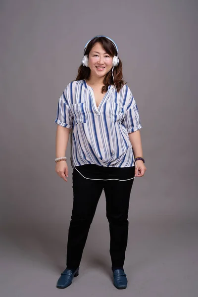 Retrato de mujer de negocios japonesa madura con auriculares —  Fotos de Stock