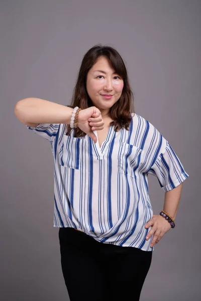 회색 배경에 대항하는 아름다운 아시아 여성 성숙기 — 스톡 사진