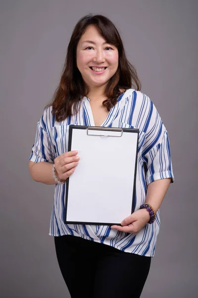 Japanska affärskvinna holding Urklipp med vita tomma papper — Stockfoto