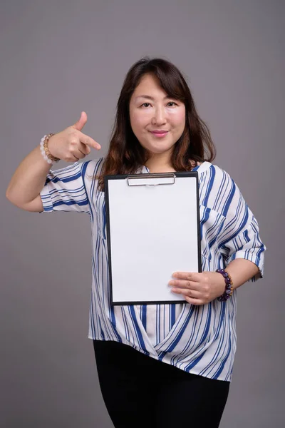 Empresária japonesa segurando prancheta com papel branco vazio — Fotografia de Stock