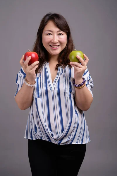 Madura hermosa mujer de negocios asiática sosteniendo fruta de manzana — Foto de Stock