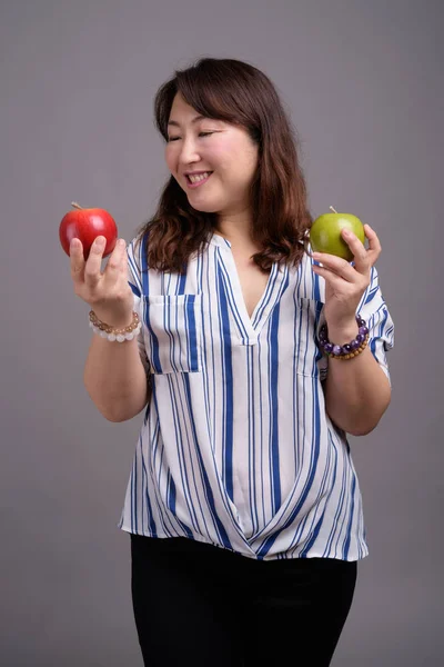 Madura hermosa mujer de negocios asiática sosteniendo fruta de manzana — Foto de Stock