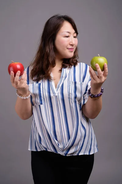 Madura hermosa mujer de negocios asiática sosteniendo fruta de manzana — Foto de Stock