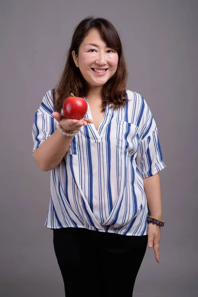 Ώριμη όμορφη ασιατικές επιχειρηματίας κρατώντας φρούτα μήλων — Φωτογραφία Αρχείου
