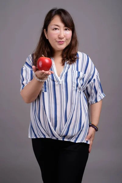 Madura hermosa mujer de negocios asiática sosteniendo fruta de manzana — Foto de Stock