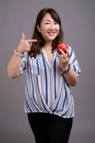 Ώριμη όμορφη ασιατικές επιχειρηματίας κρατώντας φρούτα μήλων — Φωτογραφία Αρχείου