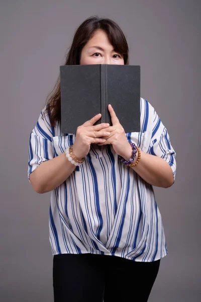 Maturo bella asiatica donna d'affari si nasconde dietro il libro — Foto Stock