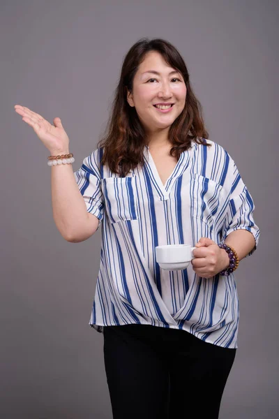 Mogen vackra asiatiska affärskvinna håller kaffekopp — Stockfoto