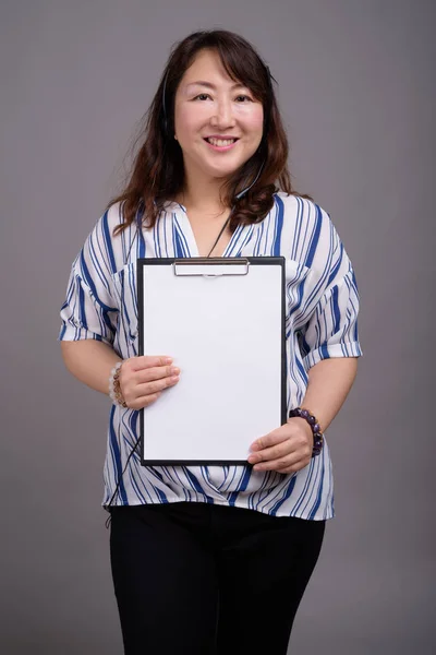 Maturo asiatico businesswoman holding appunti con copia spazio — Foto Stock