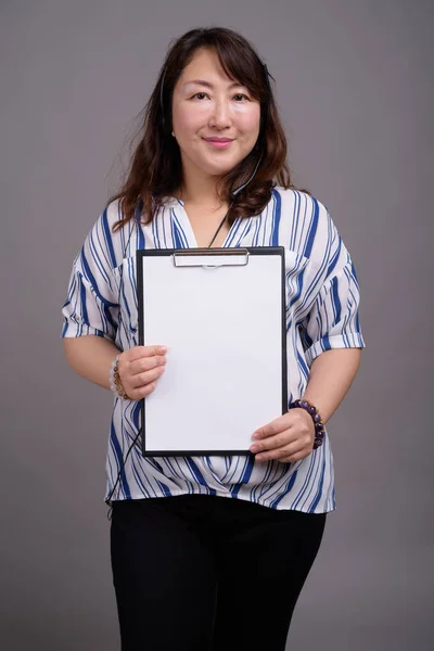 Maturo asiatico businesswoman holding appunti con copia spazio — Foto Stock