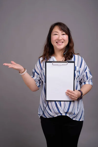 Maturo asiatico businesswoman holding appunti con copia spazio — Foto Stock