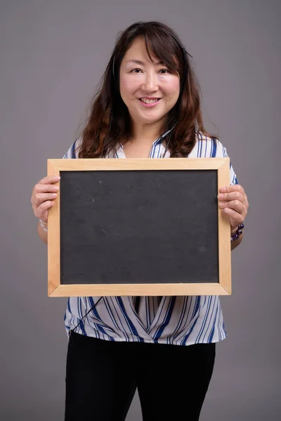 Maturo asiatico businesswoman holding lavagna con copia spazio — Foto Stock