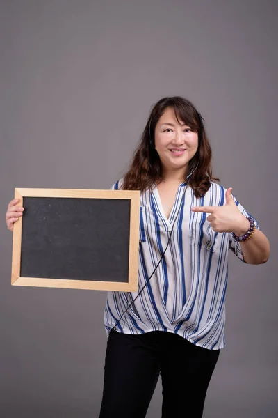 Maturo asiatico businesswoman holding lavagna con copia spazio — Foto Stock