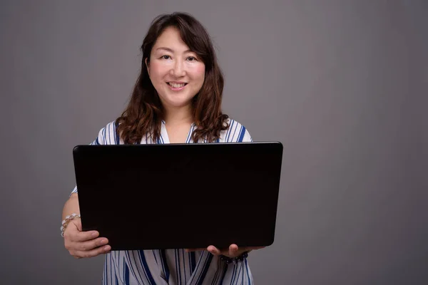 Зрелая красивая азиатская деловая женщина с ноутбуком — стоковое фото