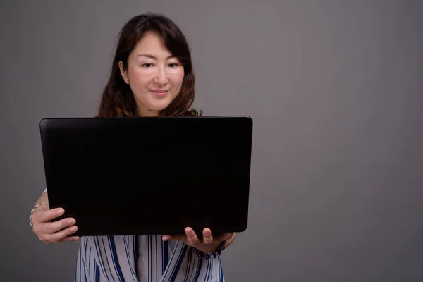 Зрелая красивая азиатская деловая женщина с ноутбуком — стоковое фото