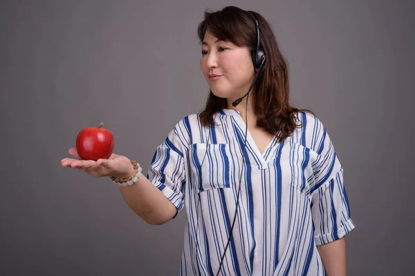 애플을 들고 성숙한 아시아 콜 센터 대표 여자 — 스톡 사진