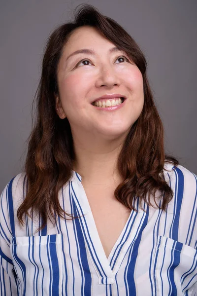 Rostro de madura hermosa mujer de negocios asiática sonriendo y pensando —  Fotos de Stock