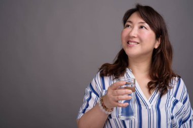 Olgun güzel Asya işkadını bardak su tutan